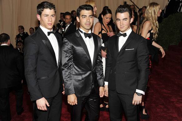 Nick Jonas, left, Joe Jonas, center and Kevin Jonas arrive at the Metropolitan Museum of Art Costume Institute gala benefit, celebrating Elsa Schiaparelli and Miuccia Prada.