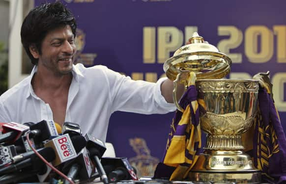 Kolkata Knight Riders team co-owner and Bollywood star Shah Rukh Khan looks at the Indian Premier League (IPL) trophy during a press conference at his residence in Mumbai.