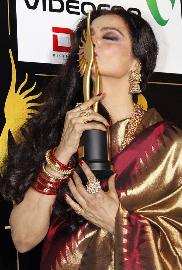 Winner of the of the Life Achievement Award, Bollywood actress Rekha kisses her award at the Jaypee International Indian Film Academy (IIFA) awards held in Singapore.