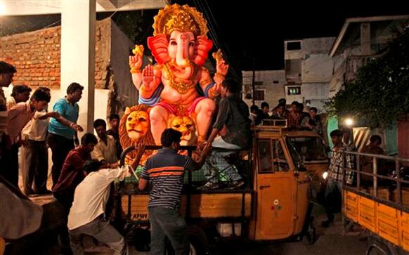 People load a giant idol of elephant-headed Hindu God Ganesha onto a truck in Hyderabad, India, Monday, Sept. 17, 2012. The ten-day Ganesh festival begins on Sept. 19 and ends with the immersion of Ganesha idols in water bodies on the last day. 