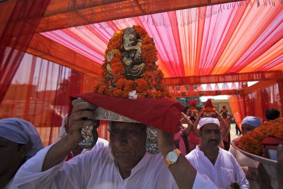 A Hindu devotee carries an idol of Hindu God Ganesha during a procession in Jammu.