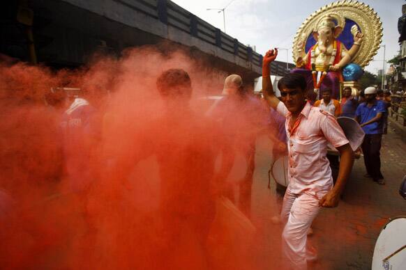 Hindu devotees dance with a huge idol of Hindu god Ganesh as they take part in a 