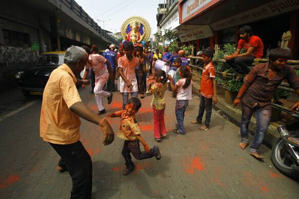 Hindu devotees dance with a huge idol of Hindu god Ganesh as they take part in a ‘Ganesh Chaturti’ festival procession in Mumbai.