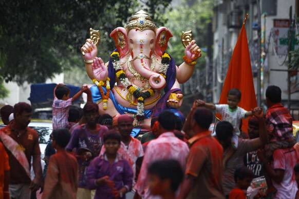 Hindu devotees dance with a huge idol of God Ganesh as they take part in a ‘Ganesh Chaturti’ festival procession in Mumbai.