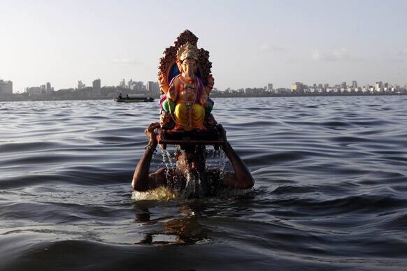 A man carries an idol of Hindu god Ganesha to immerse it in the Arabian Sea on the fifth day of the ten day long Ganesh Chaturthi festival in Mumbai.