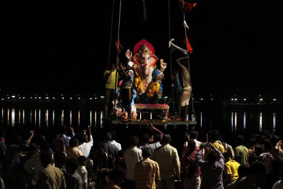 An idol of Hindu god Ganesha is lifted on a crane for immersion into the Hussain Sagar Lake in Hyderabad.