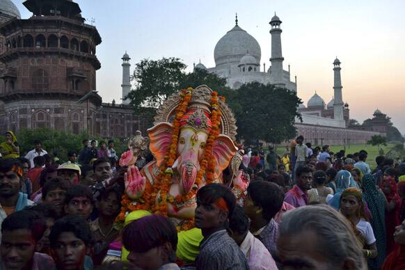 Devotees carry an idol of Hindu God Ganesha for immersion in the waters of the River Yamuna in front of the Taj Mahal monument during Ganesh Chaturthi festival in Agra.