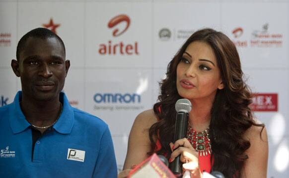 Kenyan athlete and Olympic gold medalist David Rushida, listens as Bollywood actor Bipasha Basu speaks during a press conference ahead of the Airtel Delhi Half Marathon in New Delhi.