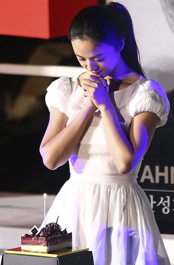 Chinese actress Tang Wei prays before blowing out a candle on her birthday cake at open talks during the Busan International Film Festival in Busan, South Korea.