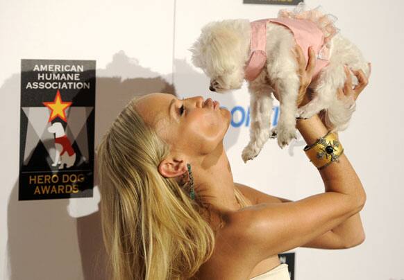 Host Kristin Chenoweth lifts up her dog 