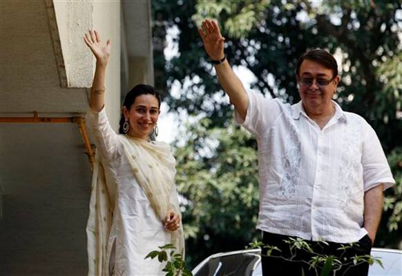 Karisma and Randhir Kapoor wave at the crowd waiting outside Saif and Kareena's residence Fortune Heights.