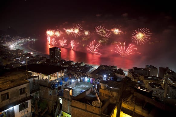 People watch fireworks exploding over Copacabana beach during New Year celebrations at the Pavao Pavaozinho slum in Rio de Janeiro, Brazil.