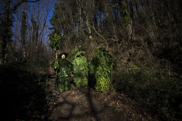 Men dressed as 'Trapajones,' representing entities of nature, wait in a forest before the start of the Vijanera festival, in the small village of Silio, northern Spain.