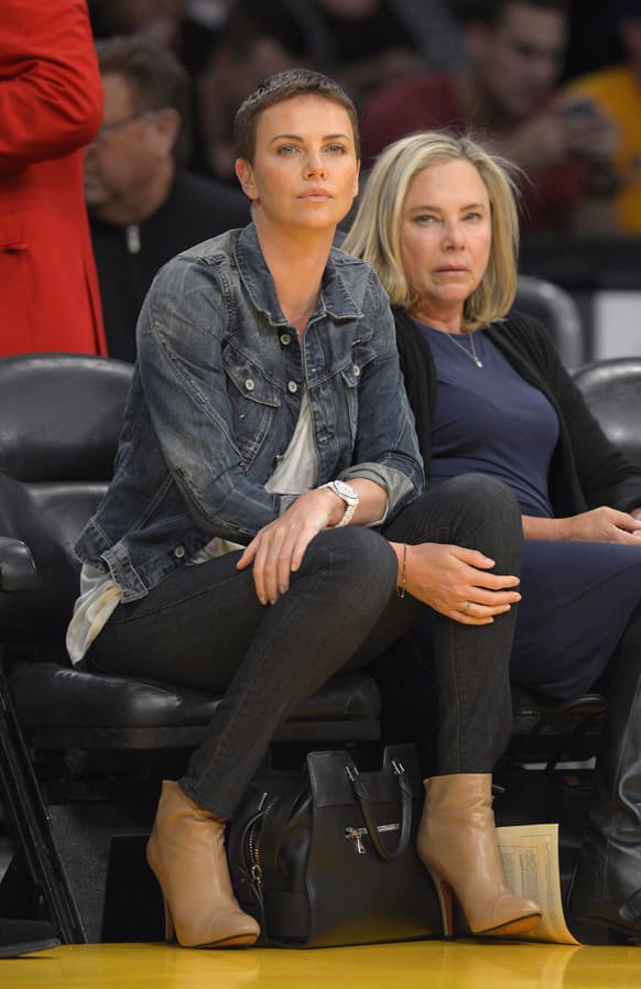 Actress Charlize Theron, left, and her mother, Gerda, watch the Los Angeles Lakers play the Oklahoma City Thunder during the first half of their NBA basketball game.