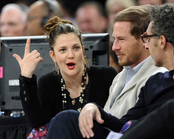 Actress Drew Barrymore, left, her husband, Will Kopelman, and John Turturro, right, talk as the New York Knicks and Chicago Bulls play in an NBA basketball game.
