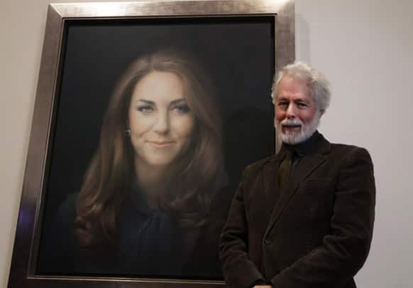 Artist Paul Emsley poses for photographers next to his newly-commissioned portrait of Kate, Duchess of Cambridge, on display at the National Portrait Gallery in London.