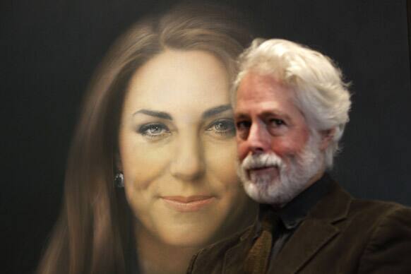 Artist Paul Emsley poses for photographers next to his newly-commissioned portrait of Kate, Duchess of Cambridge, on display at the National Portrait Gallery in London.
