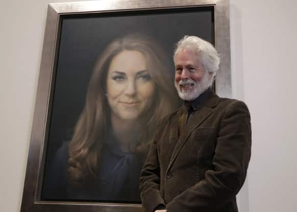 Artist Paul Emsley poses by his newly-unveiled first official portrait of Kate, Duchess of Cambridge, on display at the National Portrait Gallery in London.