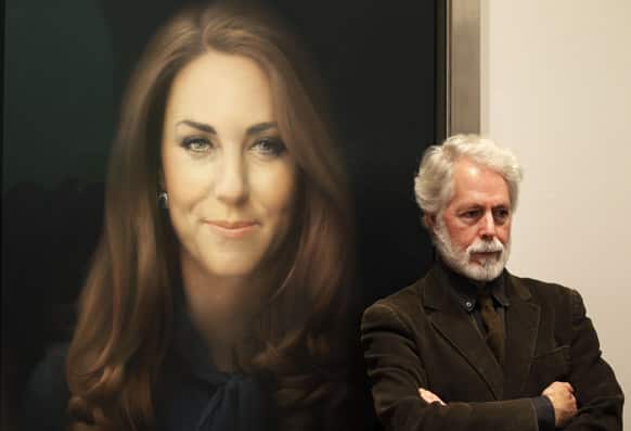 Artist Paul Emsley poses for photographers next to his newly-commissioned portrait of Kate, Duchess of Cambridge, on display at the National Portrait Gallery in London.