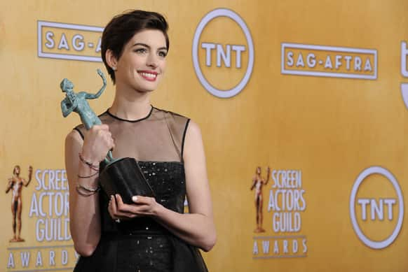 Actress Anne Hathaway poses backstage with the award for best female actor in a supporting role at the 19th Annual Screen Actors Guild Awards at the Shrine Auditorium.