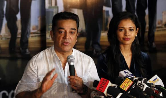 Kamal Hassan speaks as actress Pooja Kumar listens during a press conference in Mumbai.