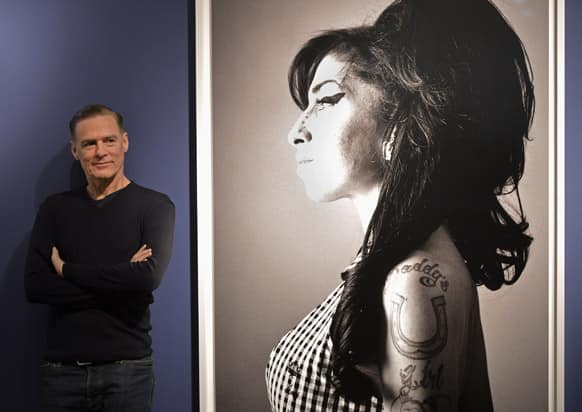 Canadian rock star Bryan Adams stands beside of one of his photo prints showing British singer Amy Winehouse during the opening of his exhibition in Duesseldorf, Germany.