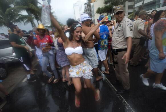 Revelers dance in the streets during the Banda de Ipanema block parade, a pre-Carnival event, in Rio de Janeiro, Brazil.