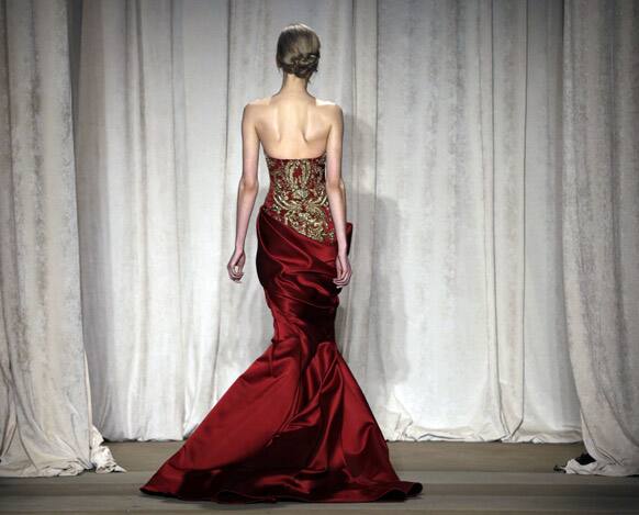 A model returns backstage after walking a runway at the conclusion of the Marchesa Fall 2013 fashion show at Fashion Week in New York.