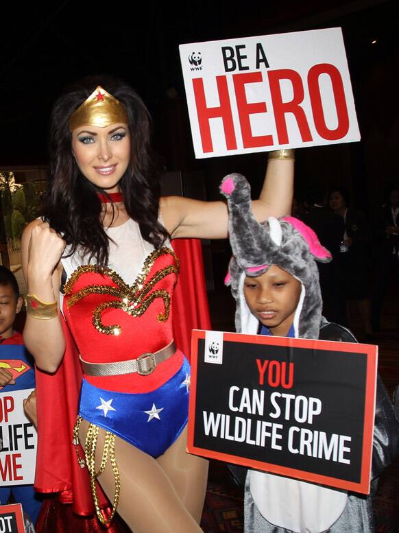 Miss Universe 2005 Natalie Glebova of Canada, wearing Wonder Woman costume poses with Thai children during Convention on International Trade in Endangered Species, or CITES, in Bangkok.
