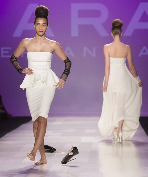 A model kicks off her remaining shoe after the other one slipped off her foot as she shows a creation from Stephan Caras while walking the runway during Toronto Fashion Week in Toronto.