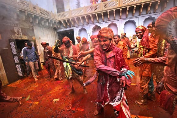 Villagers from Nandgaon throw color dye on the villagers from Barsana as they arrive at the Nandagram temple famous for Lord Krishna and his brother Balram, during Lathmar holy festival, in Nandgaon.