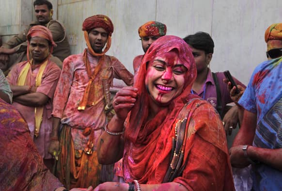 Hindu devotees smeared with colors watch others dance and play at the Nandagram temple famous for Lord Krishna and his brother Balram, during Lathmar holy festival, in Nandgaon 120 kilometers ( 75 miles) from New Delhi.