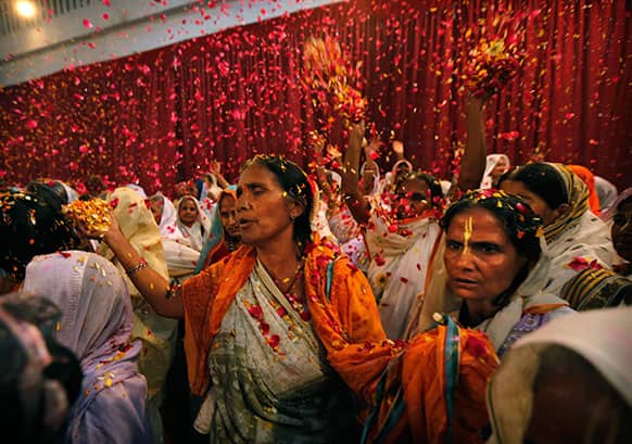 Indian widows throw flowers during Holi celebrations, or the festival of colors, at an event organized by the NGO Sulabh at the Meera Sahbhagini Ashram in Vrindavan.