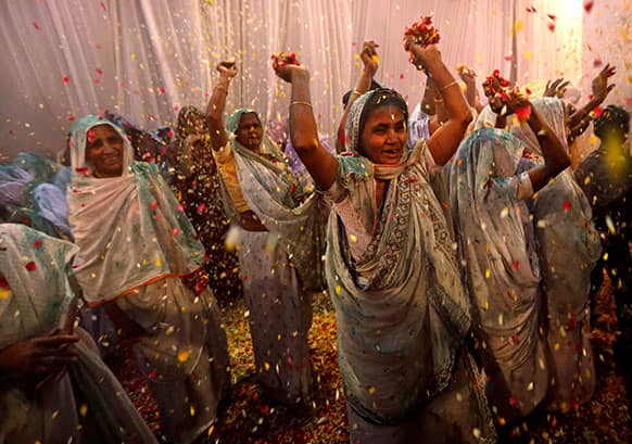 Indian widows throw flowers during Holi celebrations, or the festival of colors, at an event organized by the NGO Sulabh at the Meera Sahbhagini Ashram in Vrindavan.