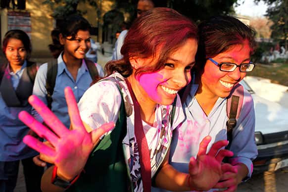 An Allahabad University student, face smeared with colored powder, gestures as she celebrates Holi, the festival of colors, in Allahabad.