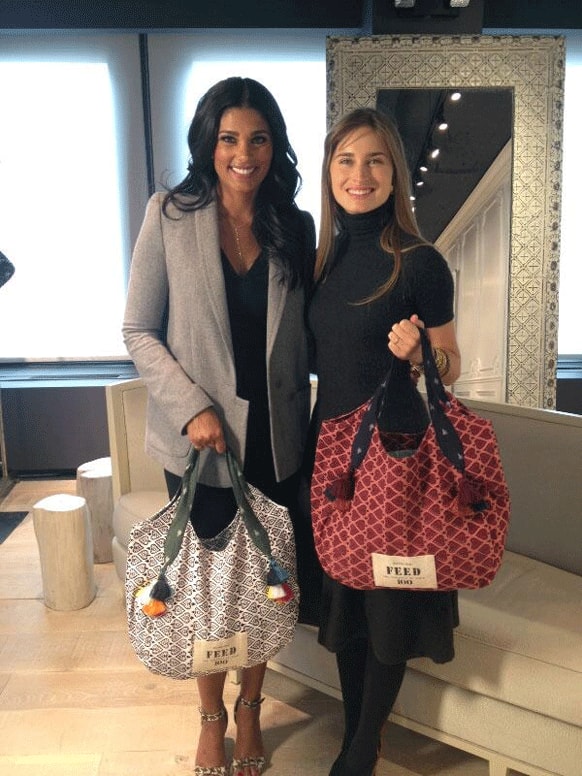 Designer-philanthropists Rachel Roy and Lauren Bush have launched a collection Feed India totes priced $78. The collections from the bags will be used to provide 100 school meals for young children in India.