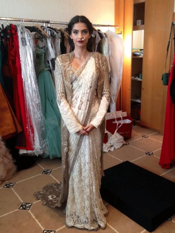 Sonam walked the red carpet on Day 1 of Cannes 2013 wearing an Anamika Khanna white lace sari with a long embroidered jacket and a pearl nathni from Sunita K jewellery line.