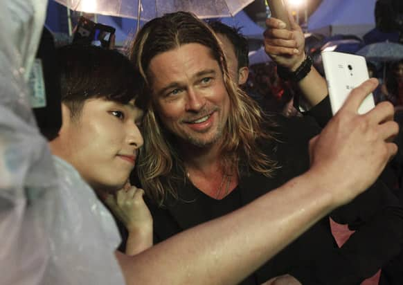 US actor Brad Pitt poses for a photo with a fan upon arrival at the South Korea premiere of his latest film 