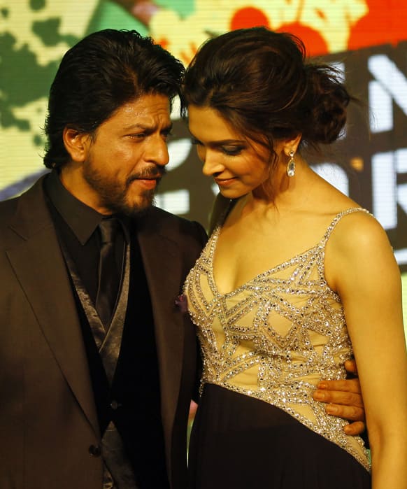 Shah Rukh Khan speaks with co actor Deepika Padukone during the music release for his upcoming movie 