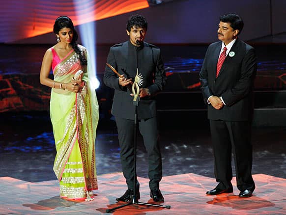 Bollywood's Sonu Nigam, center, receives the Male Playback Singer award during the International Indian Film Academy (IIFA) awards in Macau.