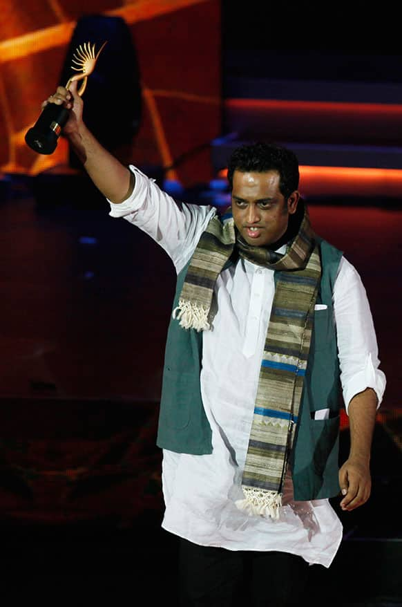 Bollywood Director Anurag Basu raises the trophy he received for Best Director during the International Indian Film Academy (IIFA) awards in Macau.