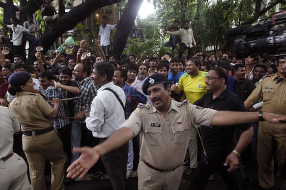 Policemen try to control a crowd gathered for the funeral of legendary actor Pran in Mumbai.