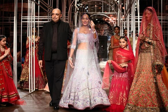 Tarun Tahiliani is seen here ushering his show stopper model Lisa Haydon on the ramp during the fashion show.