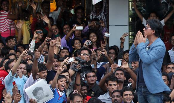 Shah Rukh Khan stand on his car and greets fans during a promotional event for his film 