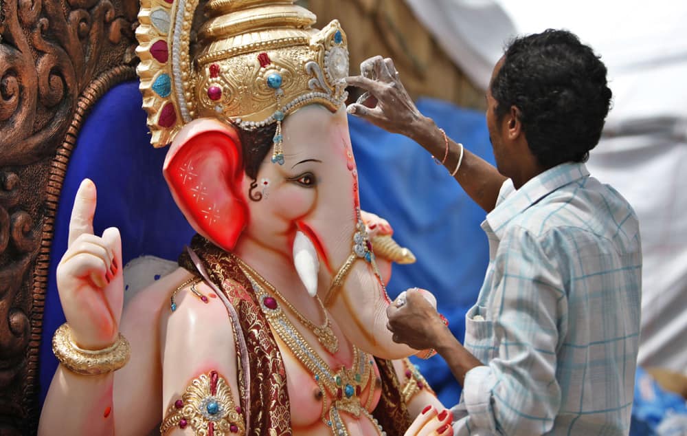 An artisan works on an idol of Hindu god Ganesh ahead of Ganesh Chaturthi festival at a workshop in Bangalore.