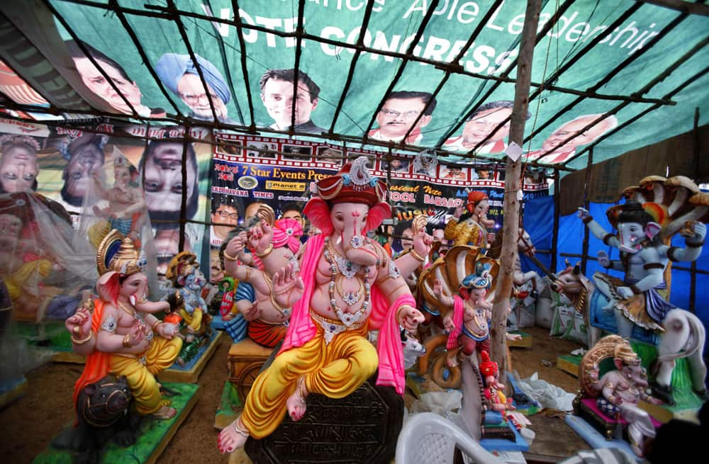 Idols of the Hindu god Ganesh are covered with a banner featuring Congress party leaders ahead of Ganesh Chaturthi festival at a workshop in Bangalore.