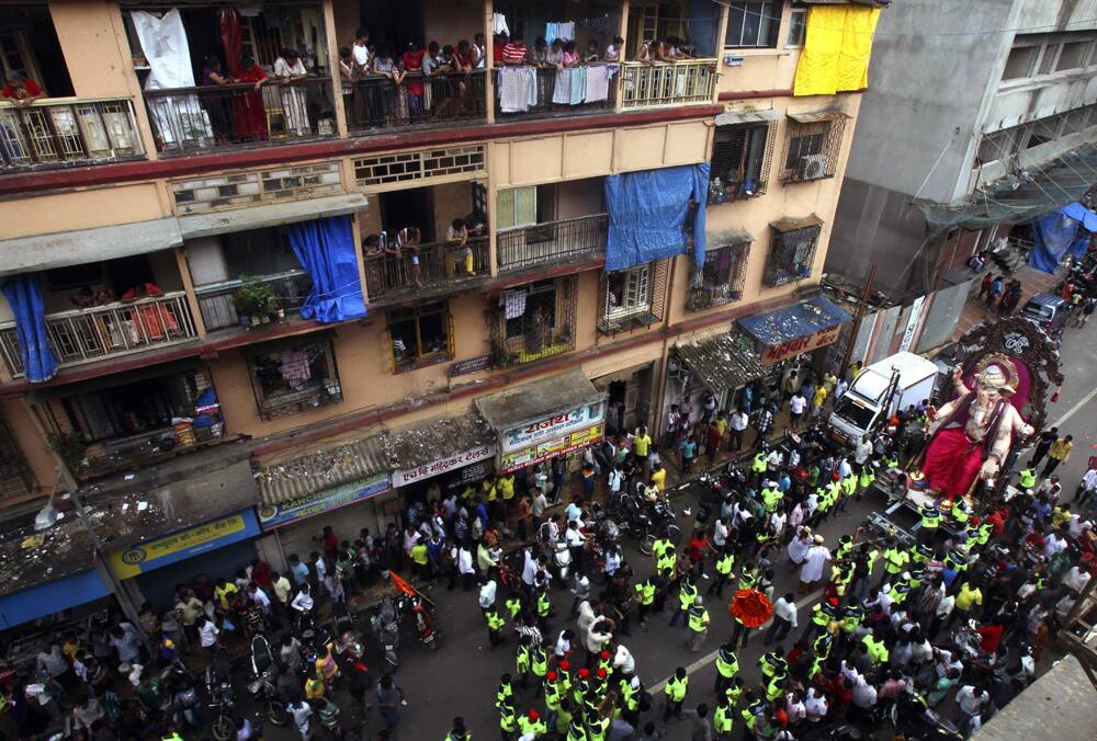 People watch as an idol of the Hindu god Ganesh is transported through a street to a place of worship in Mumbai.