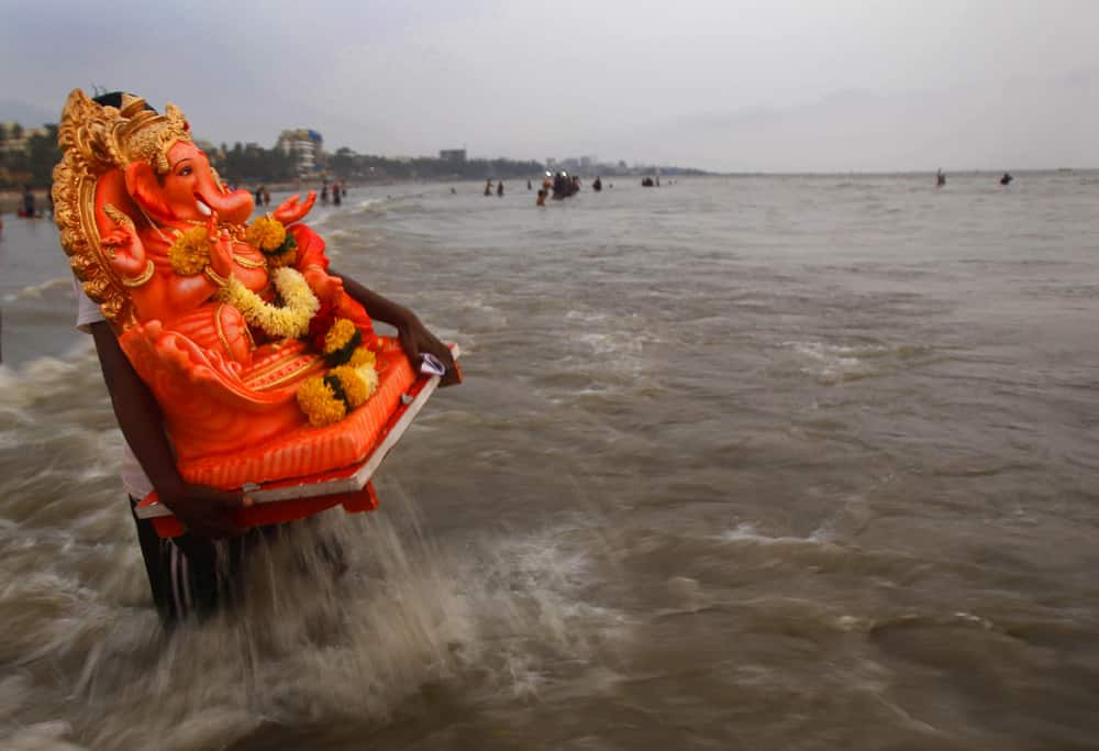 A devotee prepares to immerse an idol of elephant-headed Hindu god Ganesha in the Arabian Sea during Ganesh Chaturthi festival celebrations in Mumbai.