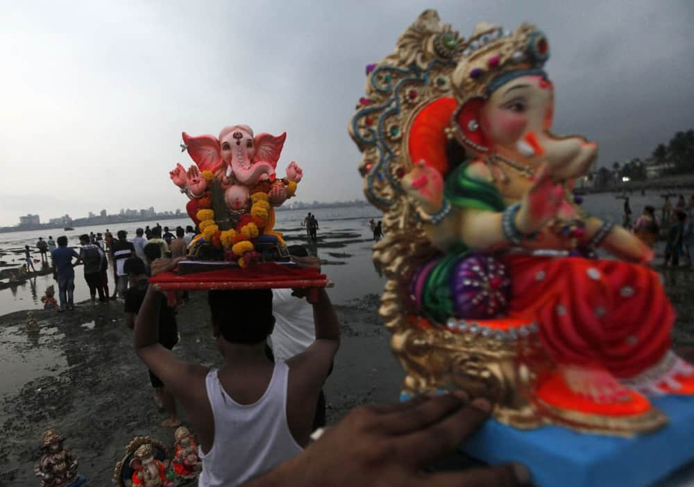 Devotees prepare to immerse idols of elephant-headed Hindu god Ganesha in the Arabian Sea during Ganesh Chaturthi festival celebrations in Mumbai.