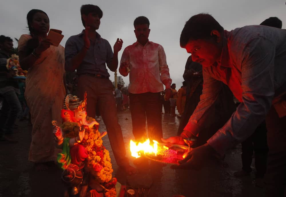 Devotees perform rituals as they prepare to immerse an idol of elephant-headed Hindu god Ganesha in the Arabian Sea during Ganesh Chaturthi festival celebrations in Mumbai.